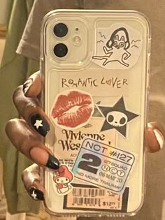 a person holding up a phone case with stickers on it