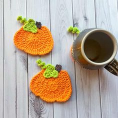 two crocheted pumpkin coasters next to a cup of coffee