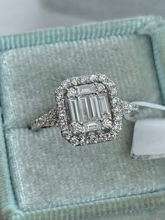 an emerald cut diamond ring in a box