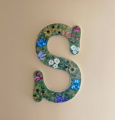 the letter s is decorated with flowers and leaves