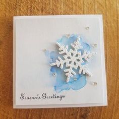 a card with a snowflake on it sitting on top of a wooden table