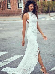 a woman in a white dress is crossing the street with her foot on the ground