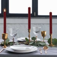 the table is set with candles, plates and silverware