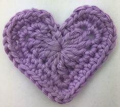 a purple crocheted heart on a white background