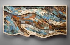 a piece of art made out of wood with blue and brown paint on it's surface