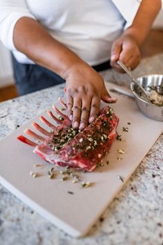 a person cutting up meat on top of a cutting board