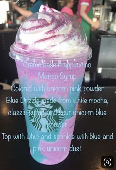 a starbucks drink with whipped cream and blueberries in it's cup on a table