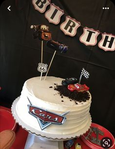 a birthday cake with cars decorations on it