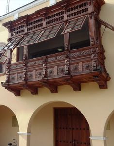 an old wooden balcony on the side of a building with arched doorways and balconies