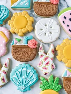 some decorated cookies are laying on a white counter top and one has watermelon