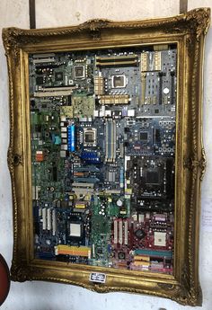 a computer motherboard is displayed in a gold frame