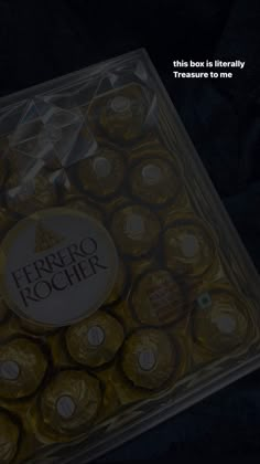 the box is filled with gold foiled chocolates and has a logo on it