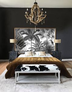 a bedroom with a bed, chandelier and black walls