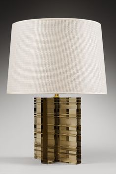 a table lamp with a white shade on it's base and gold trimmings