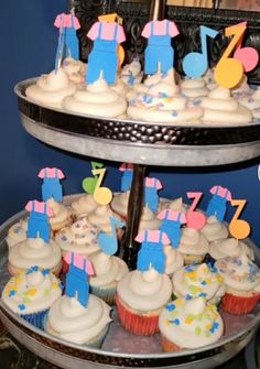 three tiered tray with cupcakes and musical notes