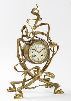 a gold clock sitting on top of a metal stand