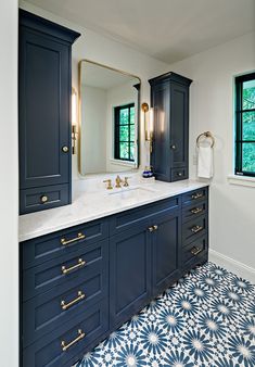 a bathroom with blue cabinets and white counter tops