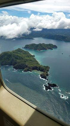 the view from an airplane window looking out at some water and land in the ocean