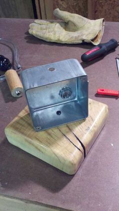 an old camera sitting on top of a wooden table next to other items and tools