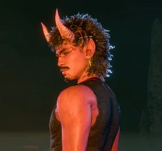 a man with horns on his head is standing in the dark