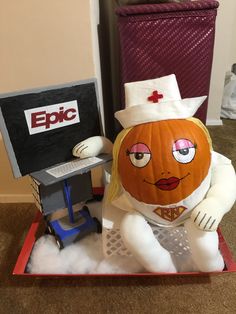 a pumpkin with a doctor's hat sitting in front of a lap top computer