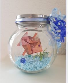 a fish in a bowl with some blue rocks