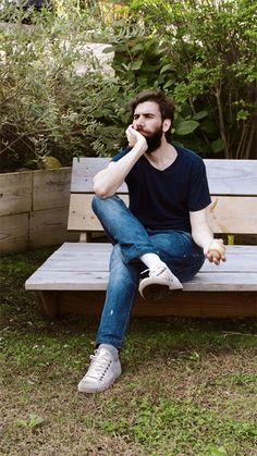 a man sitting on top of a wooden bench