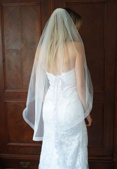 a woman in a white wedding dress with a veil on her head