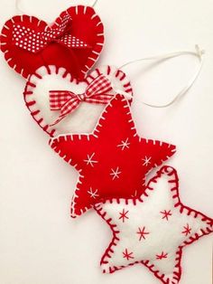 three red and white stars are hanging on the wall, one is made out of felt