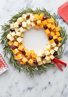 a wreath made out of cheese and olives on top of a marble countertop