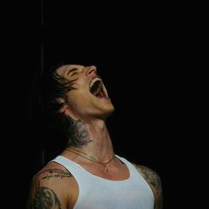 a man with his mouth open and tattoos on