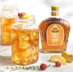 three jars filled with lemonade and raspberries next to some sliced peaches