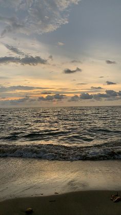 the sun is setting over the water at the beach