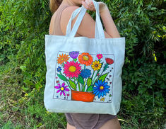 a woman carrying a bag with flowers painted on it