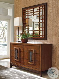 a wooden dresser sitting next to a wall with a mirror on it's side