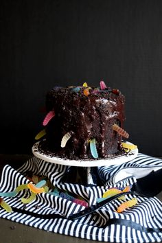 a chocolate cake with sprinkles on it sitting on top of a table