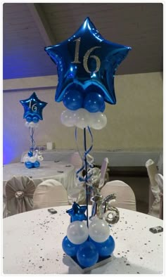 a table topped with blue and white balloons