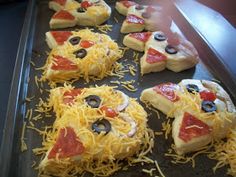 homemade pizzas with cheese, olives and pepperoni are arranged on a baking sheet