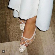 a woman's feet wearing white shoes with sequins