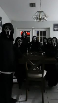 a group of people in black masks sitting around a table