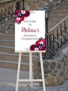 a welcome sign sitting on top of a wooden easel in front of some steps