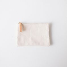 The zip pouch is handmade of heavyweight cotton canvas, with a solid brass zipper that features a leather pull for easy use. It's the perfect accessory to organize items in your tote or to carry on its own. The small zip pouch measures 5.5 inches by 7.5 inches, and the medium zip pouch measures 7 inches by 9.5 inches. Canvas Pouch For Everyday Use, Travel Cotton Zipper Pouch, Cotton Travel Pouch, Cotton Pouch With Zipper Pocket For Daily Use, Cotton Pouch With Zipper For Everyday Use, Daily Use Cotton Canvas Bag With Zipper Pouch, Cotton Pouch With Zipper Closure For Everyday Use, Minimalist Rectangular Pouch With Zipper, Minimalist Rectangular Zipper Pouch