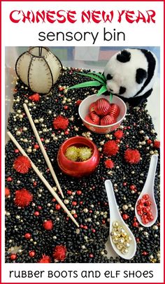 a panda bear sitting on top of a table next to some bowls and spoons