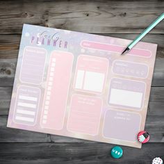 a pink planner pad sitting on top of a wooden table