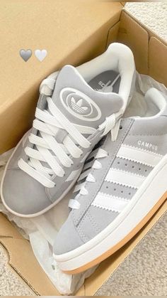 a pair of grey and white adidas sneakers in a box