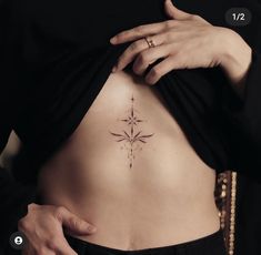 a woman with a cross tattoo on her stomach is looking down at the back of her body