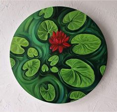 a painting on a white wall with green leaves and a red flower in the center