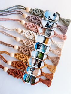 several tassels are arranged in rows on a white surface, each with different pictures