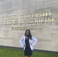 a woman standing in front of the howard university college of medicine sign with her hands on her hips