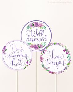 three purple and white cake toppers with flowers on them